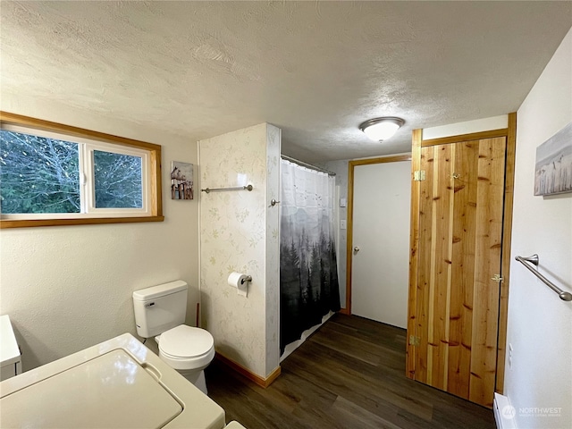 bathroom with toilet, baseboards, a textured ceiling, and wood finished floors