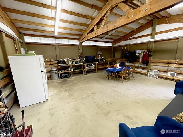 interior space with freestanding refrigerator and a workshop area