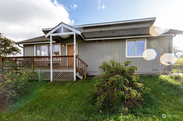 view of front facade featuring a wooden deck and a front lawn