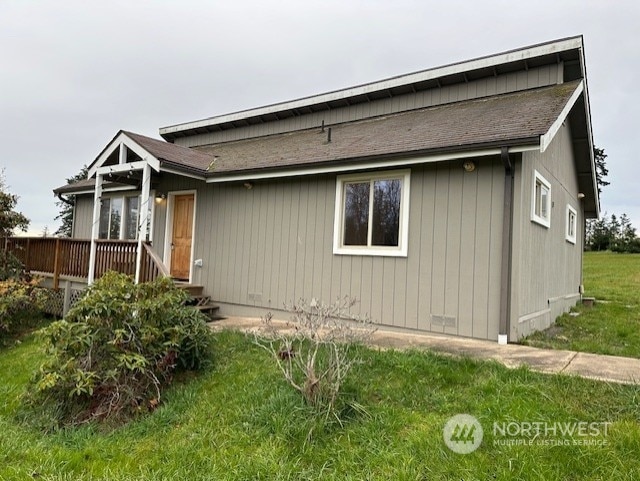 view of front of property with a wooden deck and a front yard