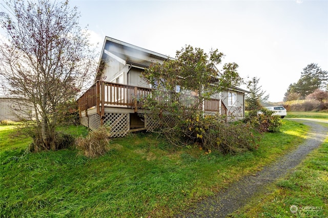 view of side of property featuring a lawn and a deck