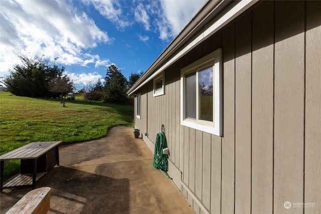 view of property exterior with a lawn and a patio area