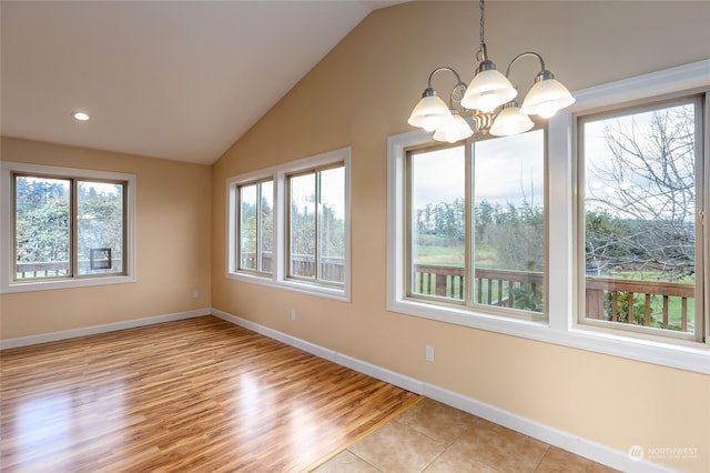 interior space with light hardwood / wood-style flooring, lofted ceiling, and a notable chandelier