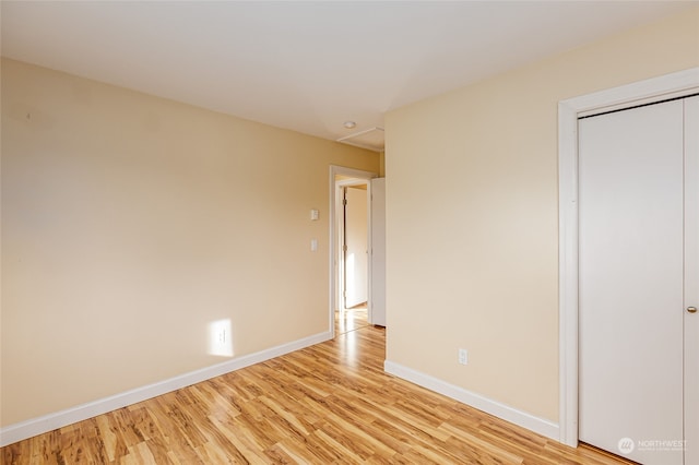 unfurnished bedroom featuring light hardwood / wood-style floors and a closet