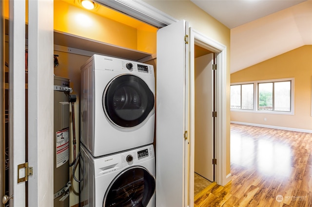 laundry area with light wood-type flooring, stacked washer / dryer, and water heater