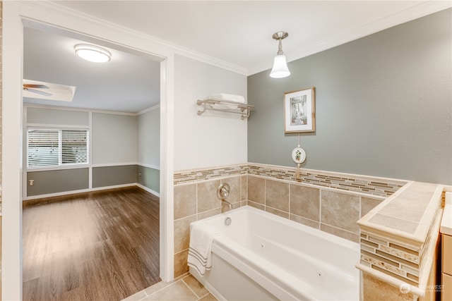 bathroom with a bathing tub, vanity, ornamental molding, and hardwood / wood-style floors