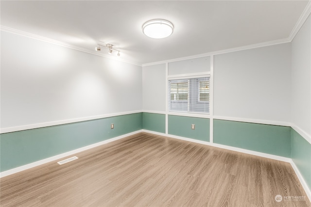 spare room with hardwood / wood-style flooring and ornamental molding