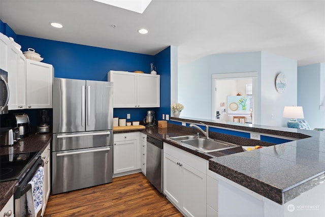 kitchen featuring kitchen peninsula, appliances with stainless steel finishes, and white cabinetry