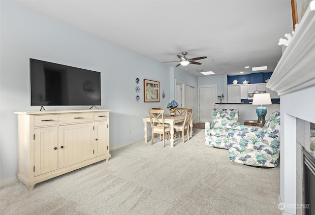 carpeted living room with ceiling fan