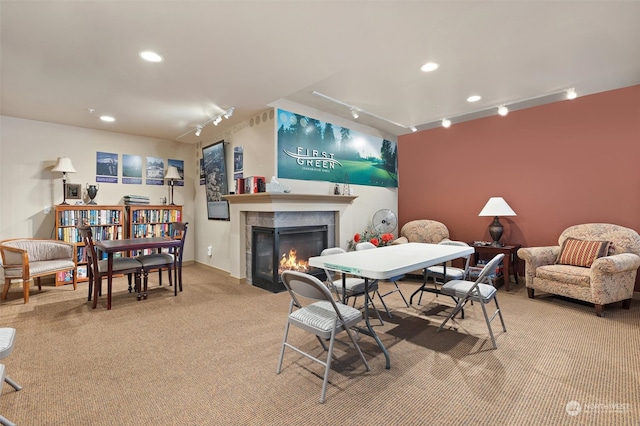 carpeted dining area with a fireplace and track lighting