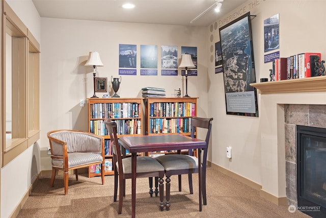 living area featuring carpet flooring, track lighting, and a tiled fireplace