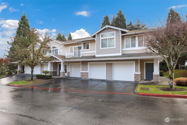 view of front of property featuring a balcony and a garage