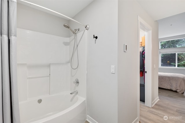 bathroom with wood-type flooring and shower / tub combo