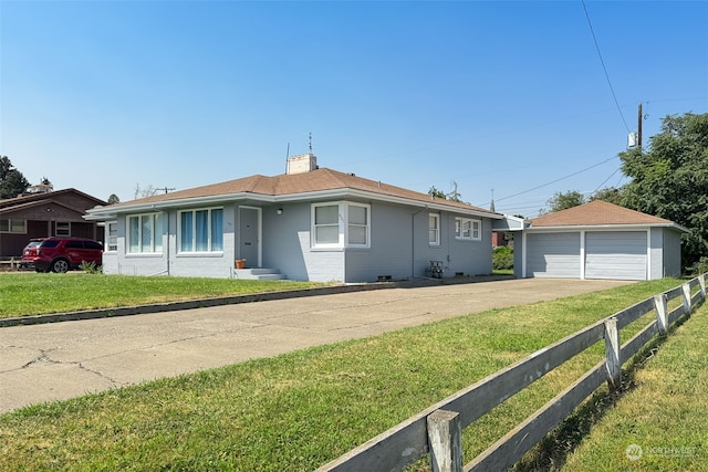 single story home with an outbuilding, a garage, and a front lawn