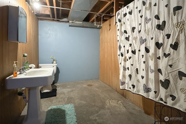 bathroom featuring shower / bath combo, concrete flooring, and wooden walls