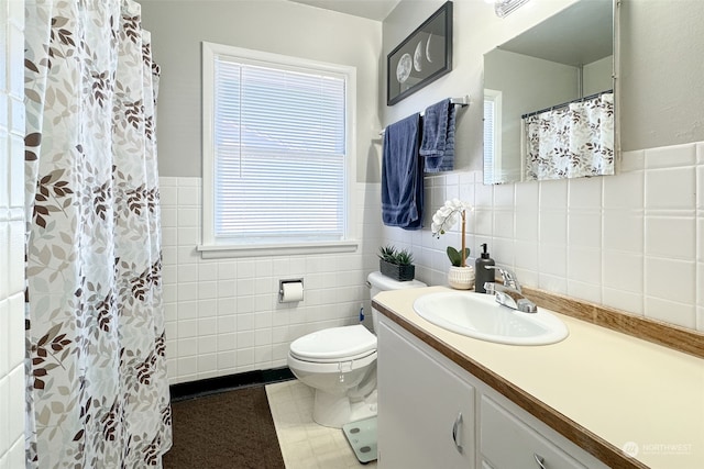 bathroom with tile patterned floors, plenty of natural light, tile walls, and vanity