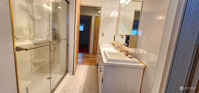 bathroom with hardwood / wood-style floors, vanity, and walk in shower