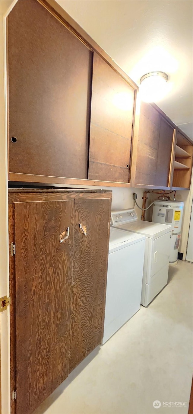 laundry area with washing machine and clothes dryer, water heater, and cabinets