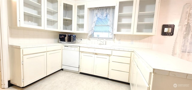 kitchen with dishwasher, tasteful backsplash, white cabinetry, and sink