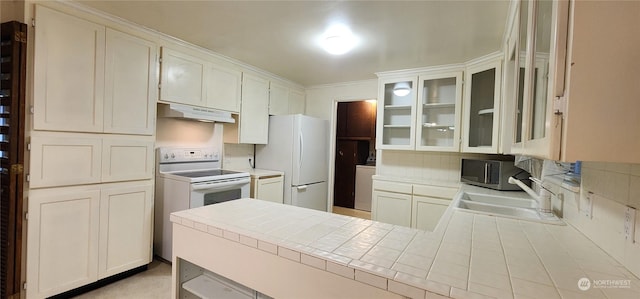 kitchen featuring backsplash, white appliances, sink, white cabinetry, and tile counters