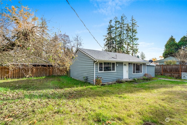 rear view of house featuring a lawn