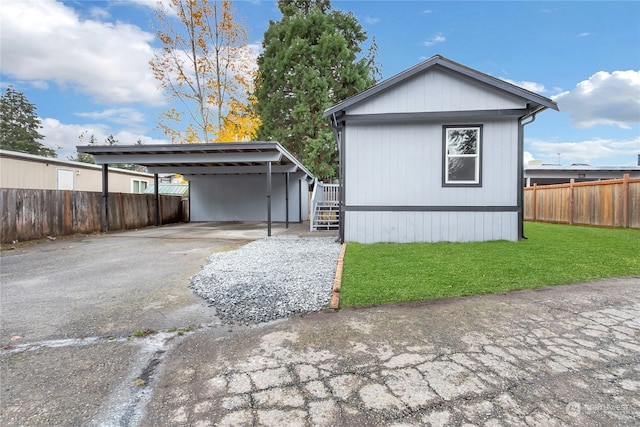 view of side of property with a carport and a lawn