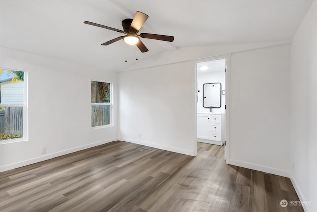 unfurnished room with a healthy amount of sunlight, lofted ceiling, and wood-type flooring