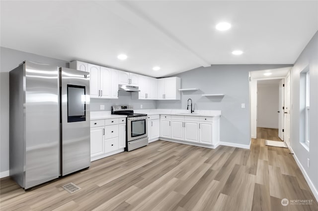 kitchen with white cabinets, sink, stainless steel appliances, and vaulted ceiling