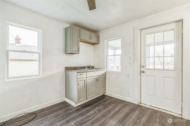 kitchen with gray cabinets, sink, and dark wood-type flooring