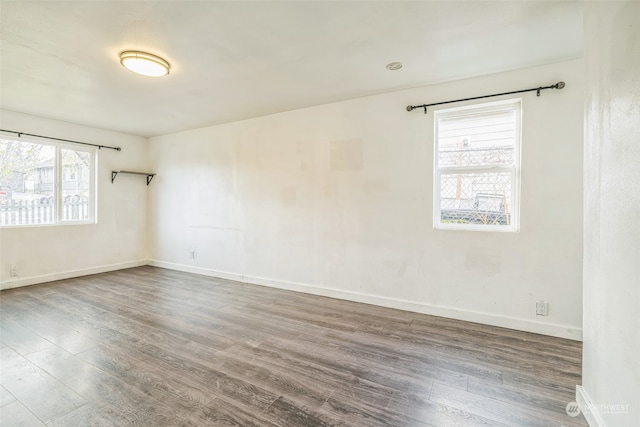 spare room with hardwood / wood-style floors and plenty of natural light