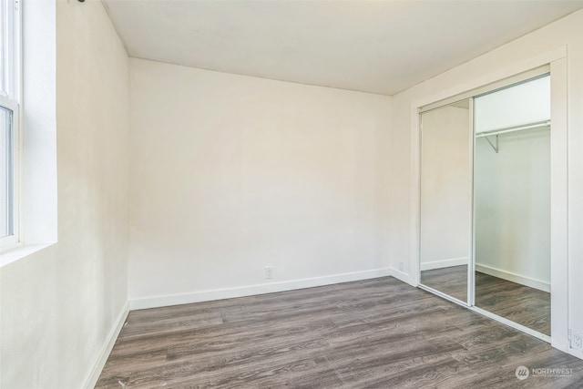 unfurnished bedroom featuring a closet and dark hardwood / wood-style flooring