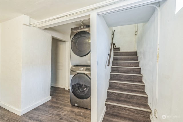 clothes washing area featuring dark hardwood / wood-style floors and stacked washer and dryer