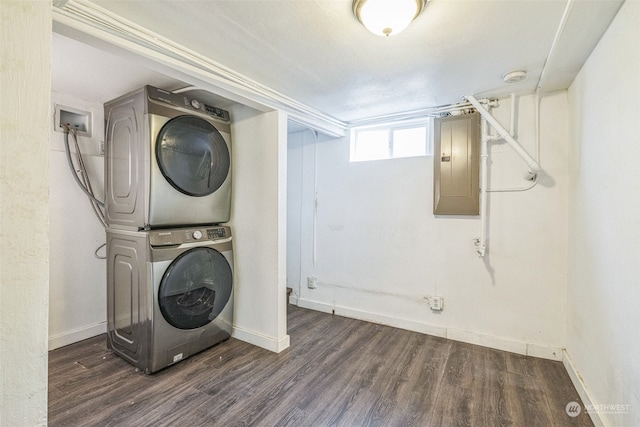 laundry area with dark hardwood / wood-style flooring, electric panel, and stacked washer / dryer