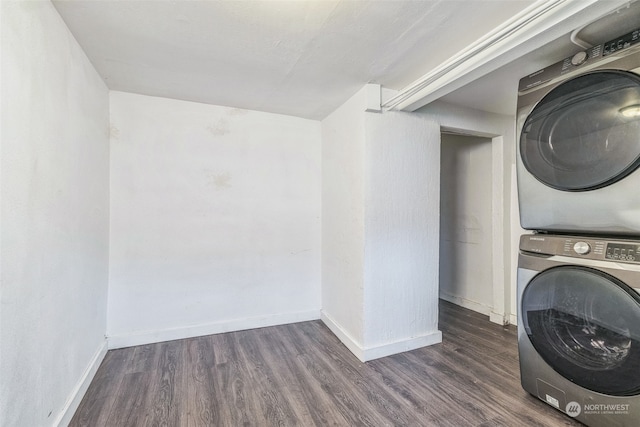 clothes washing area with stacked washer and dryer and dark wood-type flooring