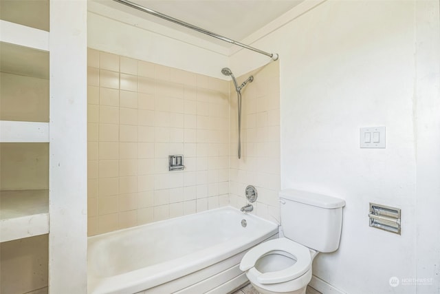 bathroom with toilet and tiled shower / bath