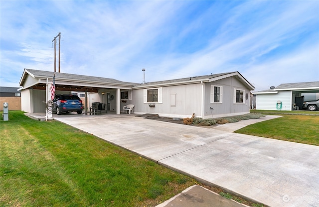 back of house featuring a carport and a lawn