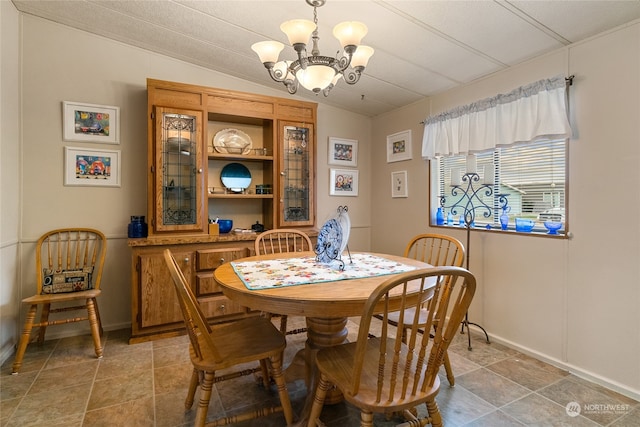 dining space with lofted ceiling and an inviting chandelier