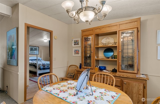 dining room with light hardwood / wood-style floors and an inviting chandelier