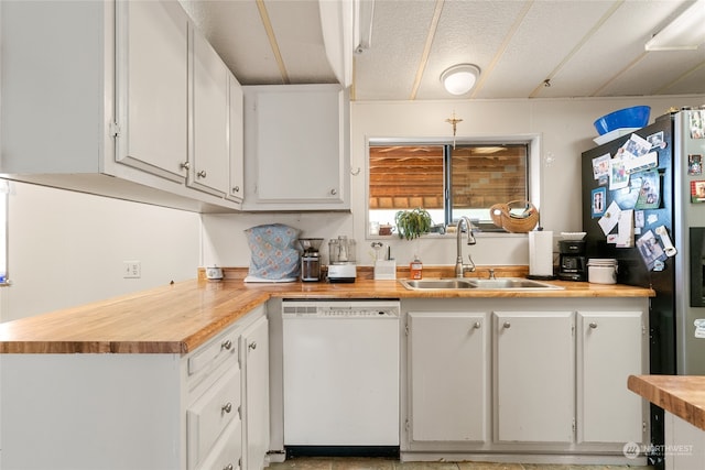 kitchen with a textured ceiling, white dishwasher, sink, butcher block countertops, and white cabinetry