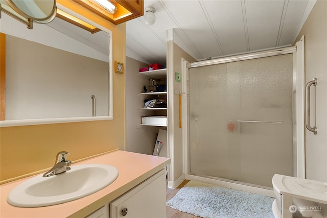 bathroom with vanity, hardwood / wood-style flooring, walk in shower, and lofted ceiling