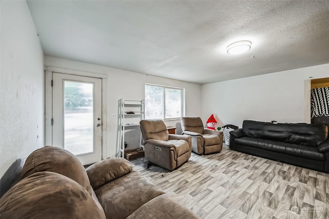 living room with a textured ceiling and light hardwood / wood-style flooring