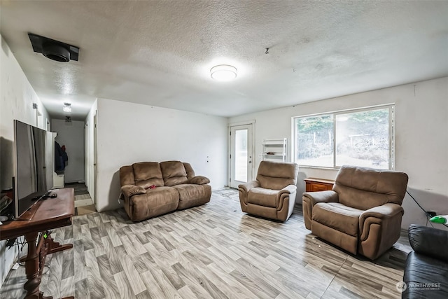 living room featuring a textured ceiling and light hardwood / wood-style flooring