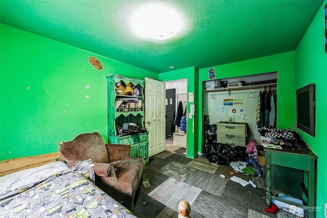 bedroom with a textured ceiling and a closet