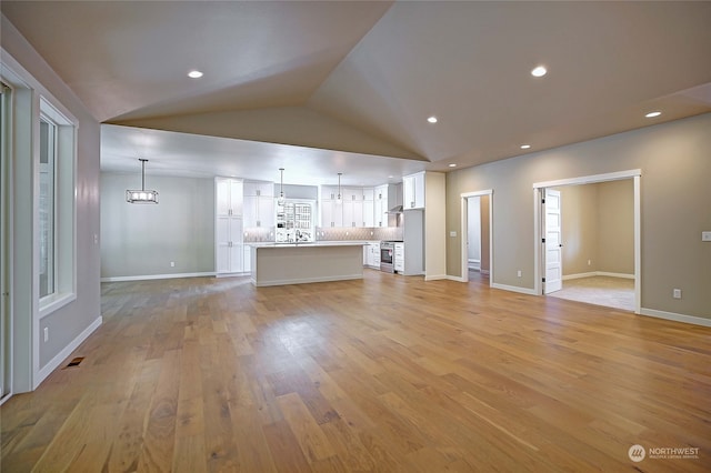 unfurnished living room with light hardwood / wood-style flooring and vaulted ceiling