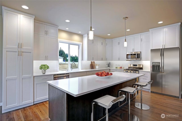 kitchen with white cabinetry, a breakfast bar, sink, and appliances with stainless steel finishes