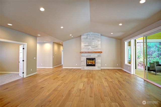 unfurnished living room featuring a fireplace, light hardwood / wood-style floors, and lofted ceiling