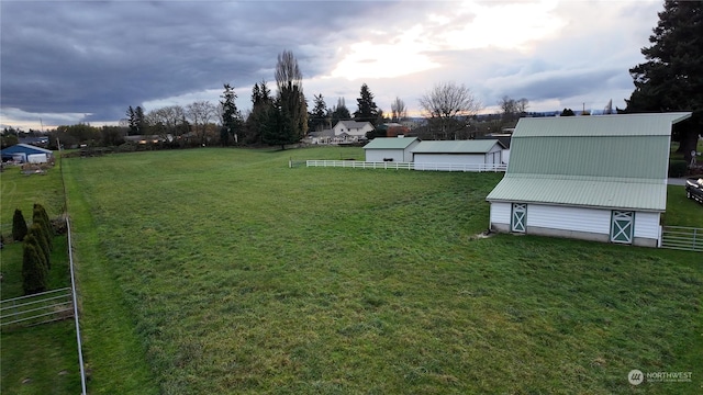 yard at dusk featuring an outdoor structure