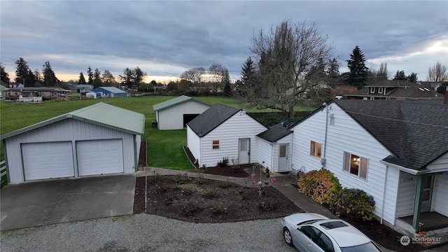 view of front of home with a lawn, a garage, and an outdoor structure