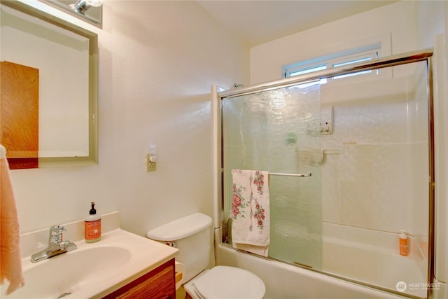 full bathroom featuring vanity, toilet, and bath / shower combo with glass door