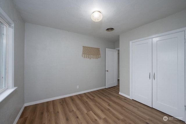 unfurnished bedroom featuring light wood-type flooring and a closet